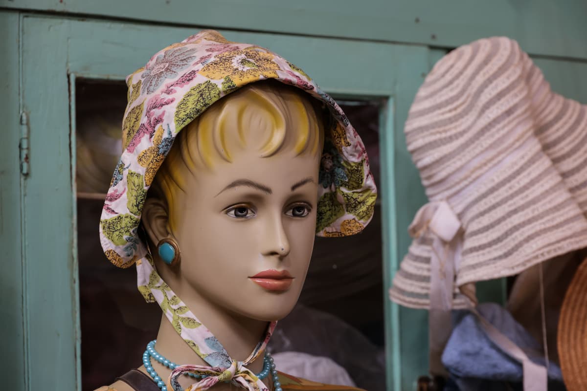 Hand touching a vintage silk scarf in a decorated shop window